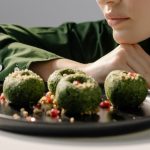 Close-up of spinach pkhali, a Georgian vegan dish, with a woman in green observing.
